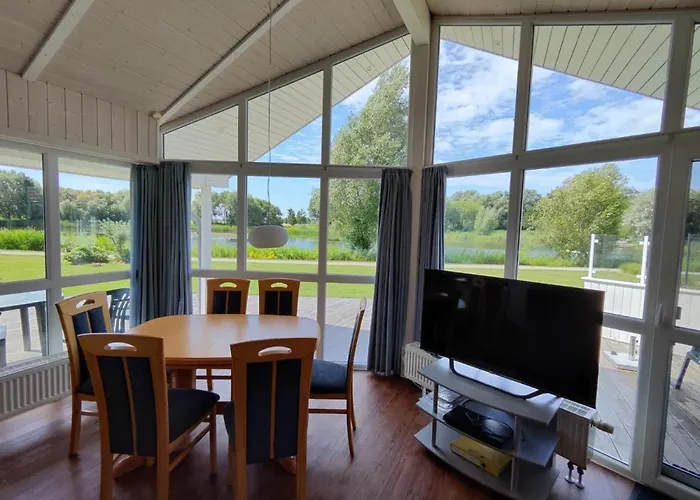 6 Personen Ferienhaus in 1. Reihe zum See mit Kanu und herrlichem Seeblick, Sauna, Whirlpool, Kaminofen, Klimaanlage und E-Tankstelle am Haus in Otterndorf